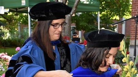a graduate is hooded at a UO graduation